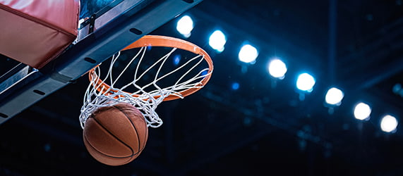 A basketball hoop in a dimly lit stadium