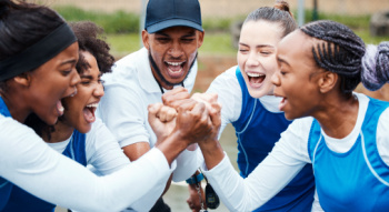 a team cheering with their coach