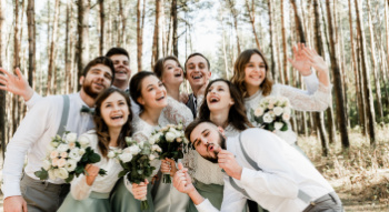 wedding guests smiling for photos with the bride and groom